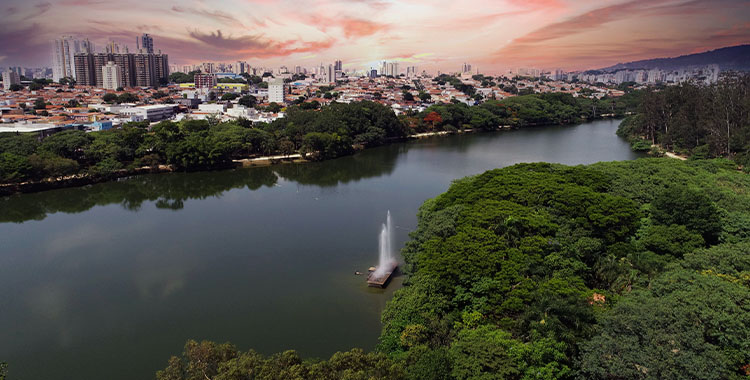 Imagem mostrando a cidade de Cambuí de cima com prédios, e um lago grande e vegetação