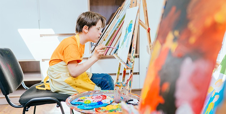 Uma fotografia que ilustra uma criança pintando.