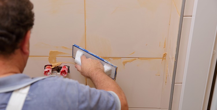 Uma fotografia de um homem fazendo uma raspagem numa parede. 