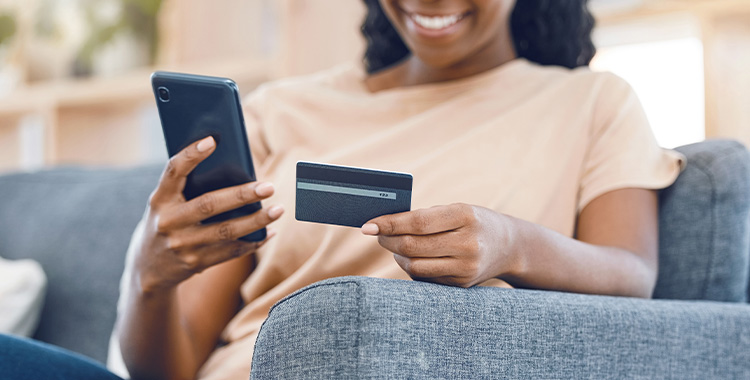 Uma imagem de uma mulher segurando um cartão de crédito