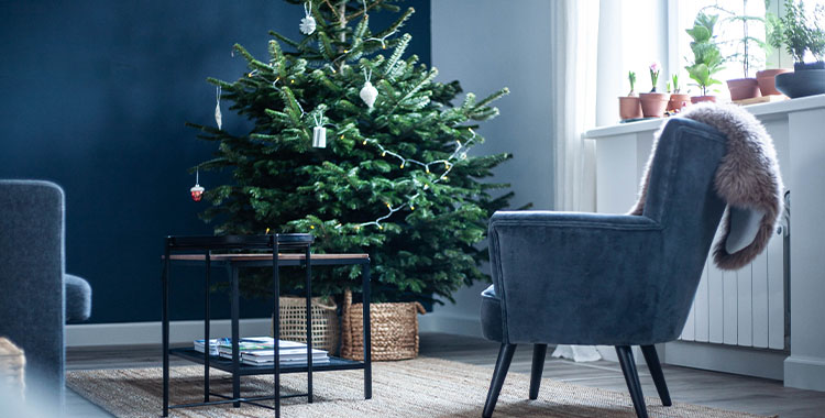 Uma imagem de uma decoração de Natal minimalista no tom de azul com árvore e poltrona
