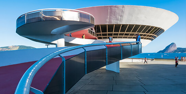 Uma fotografia externa do museu MAC, um museu de arte contemporânea projetado por Oscar Niemeyer, localizado em uma colina na cidade de Niterói