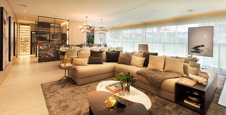 Uma fotografia de uma sala luxuosa com sofá grande, tapete e bem iluminado
