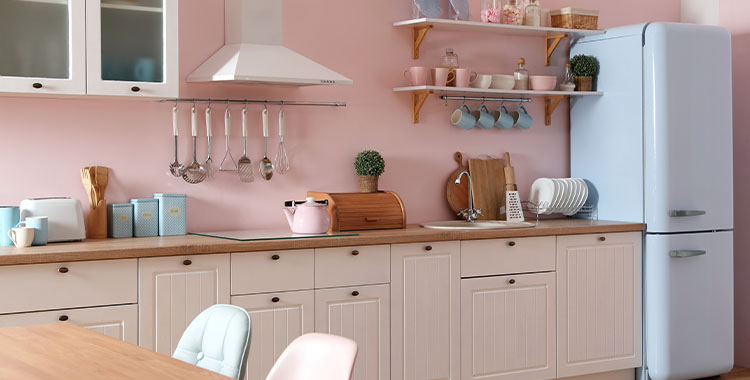 Uma foto de uma cozinha retrô com vários objetos ao redor no tom rosa