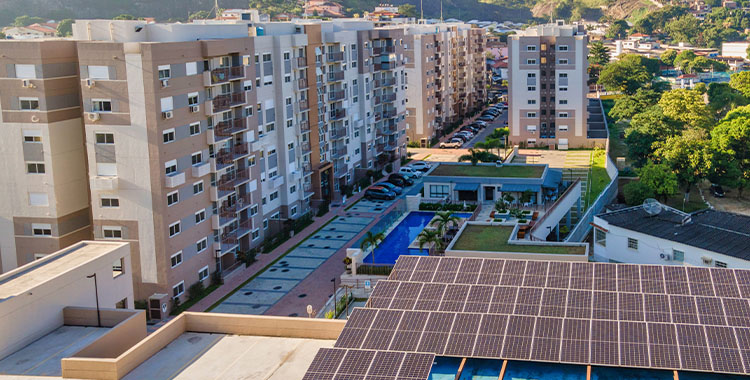 Fotografia tirada de cima mostrando prédios e placas de energia solar