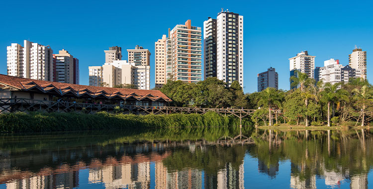 Fotografia mostrando Prédios de apartamentos refletidos na água do parque público na cidade de Curitiba, Brasil