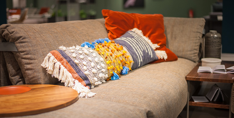 Uma fotografia mostrando uma almofada em cima de um sofá
