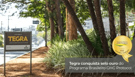 Tegra Incorporadora: Selo Ouro GHG Protocol 2022 Placa da Tegra Incorporadora em área verde, destacando o selo ouro 2022 do Programa Brasileiro GHG Protocol
